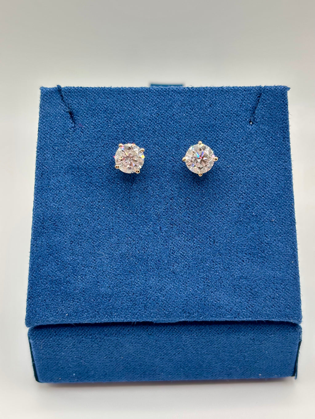 Lab diamond stud earrings in 14K yellow gold martini setting, front view on blue box