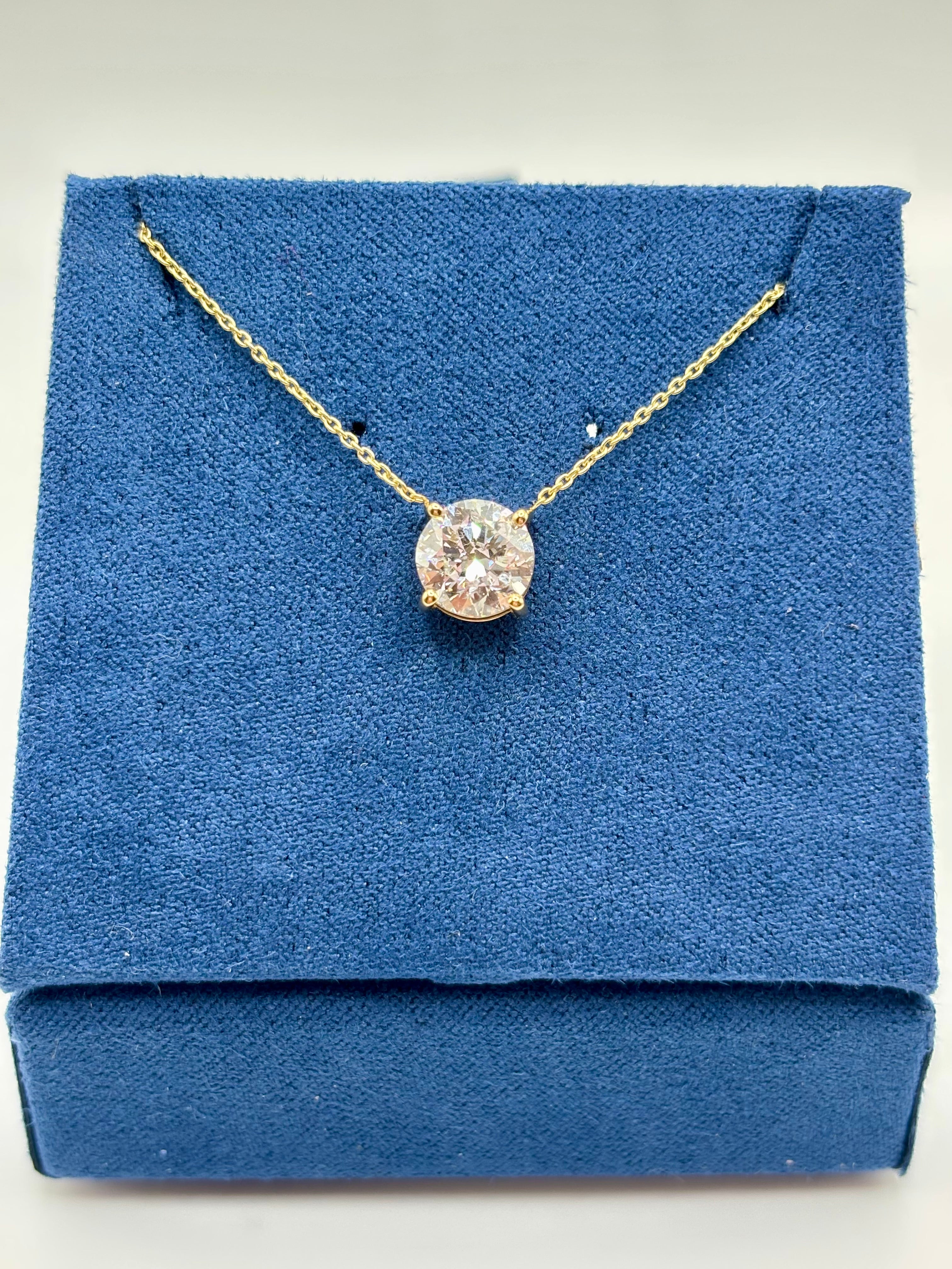 Pink lab diamond solitaire necklace in 14K yellow gold, angled view on blue box
