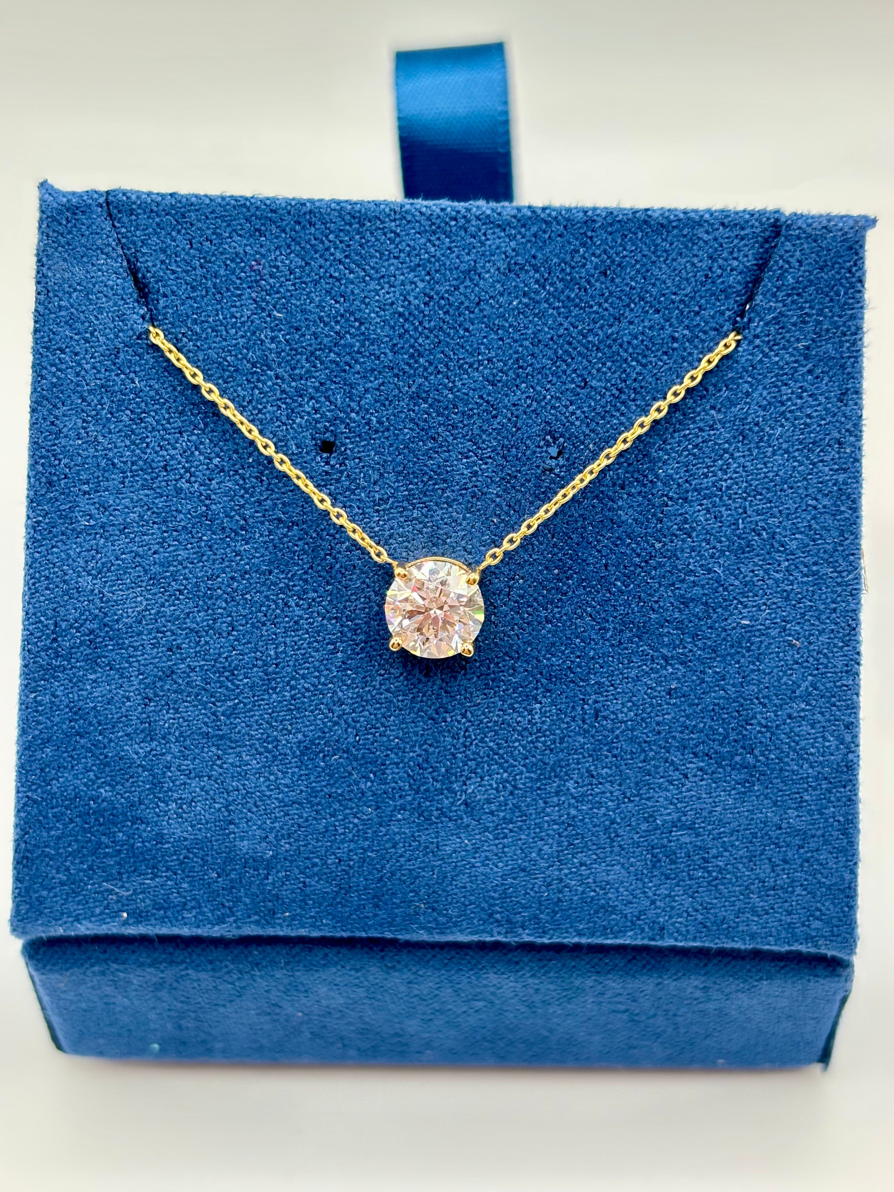 Lab diamond solitaire necklace displayed on blue jewelry box