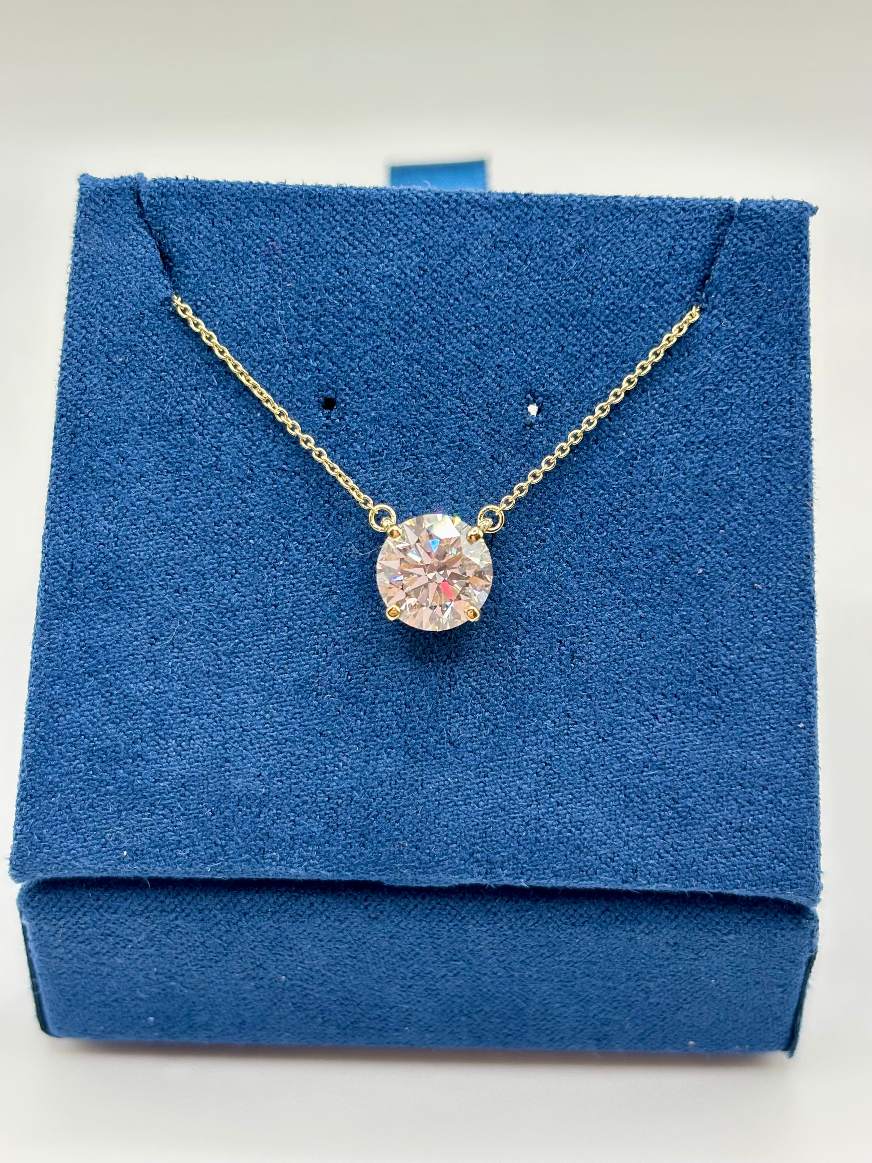 2 carat lab diamond solitaire station necklace in 14K yellow gold on blue velvet box, top view