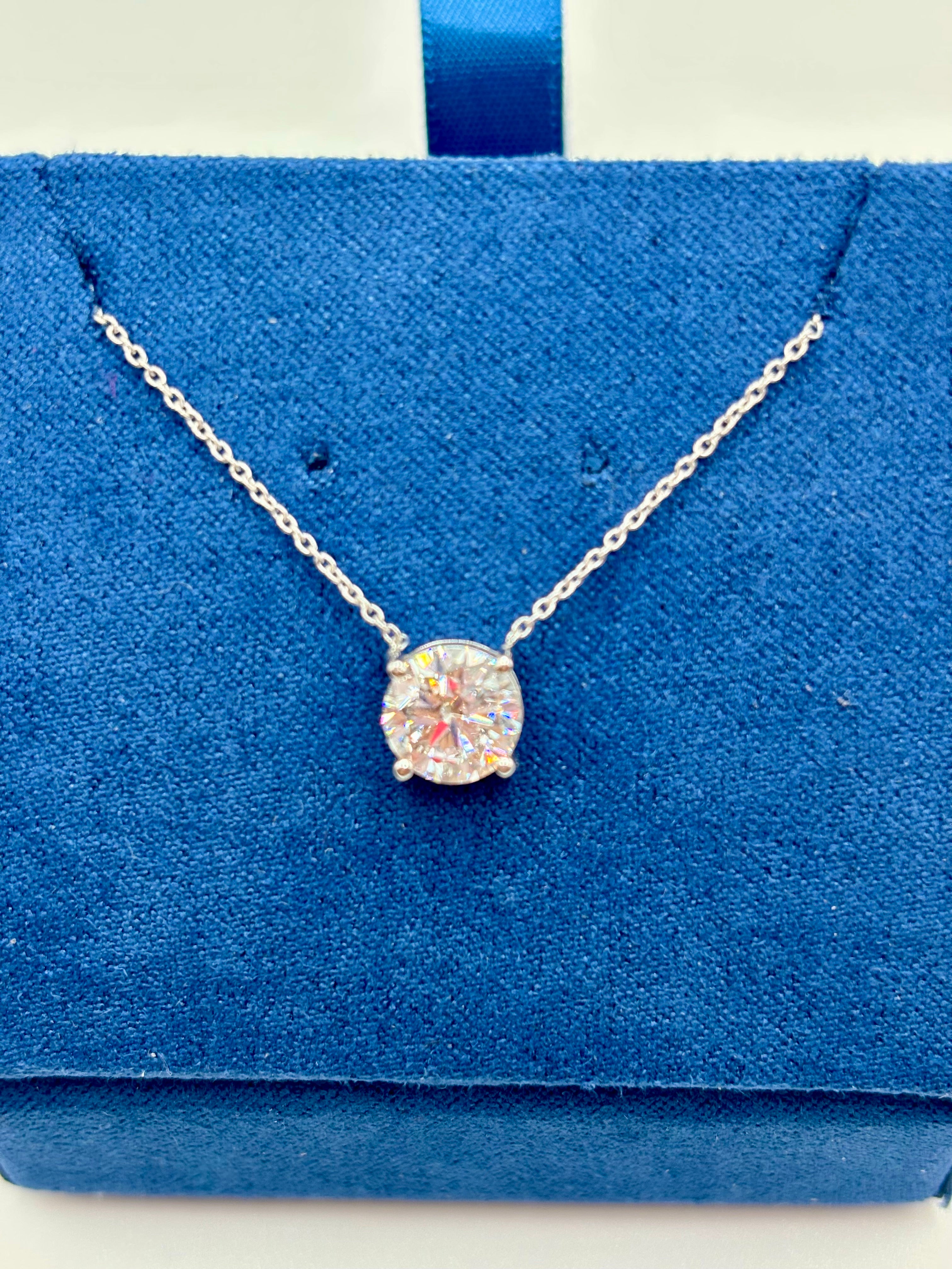 Round brilliant 1.5 carat lab diamond solitaire necklace in white gold, close-up on blue box