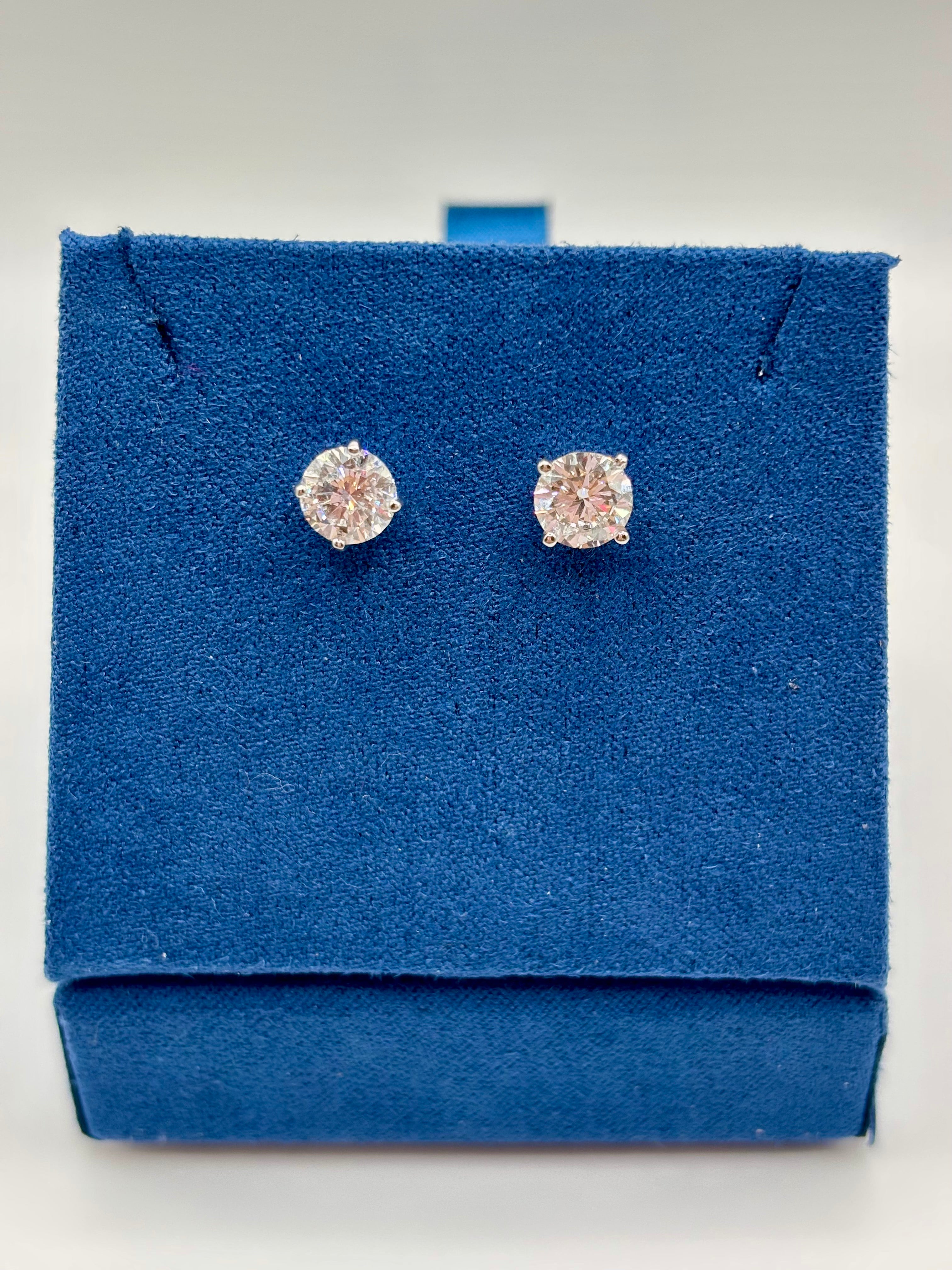 2 CTW lab diamond solitaire stud earrings in 14K white gold on blue velvet box, top view