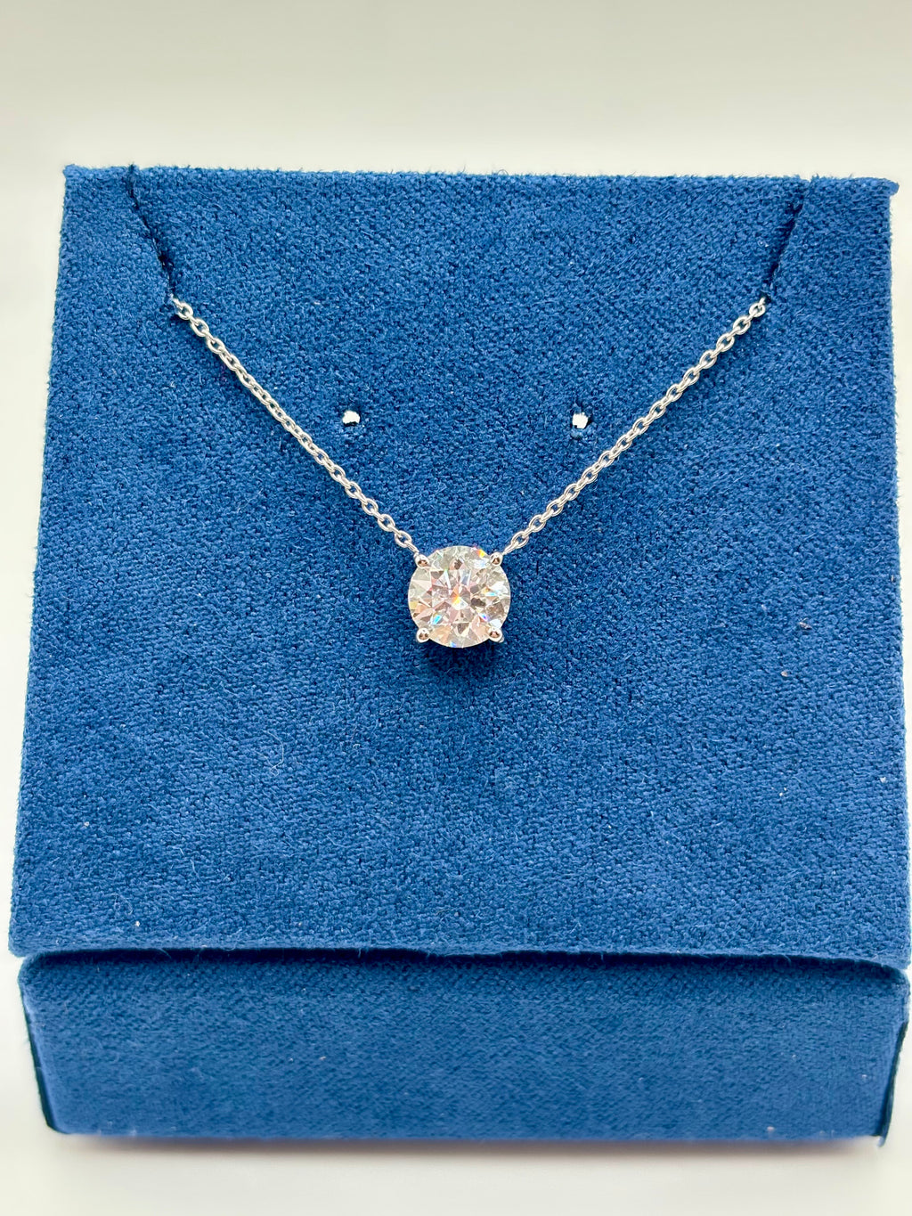 1.5 carat lab grown diamond station necklace in 14K white gold on blue box, close-up