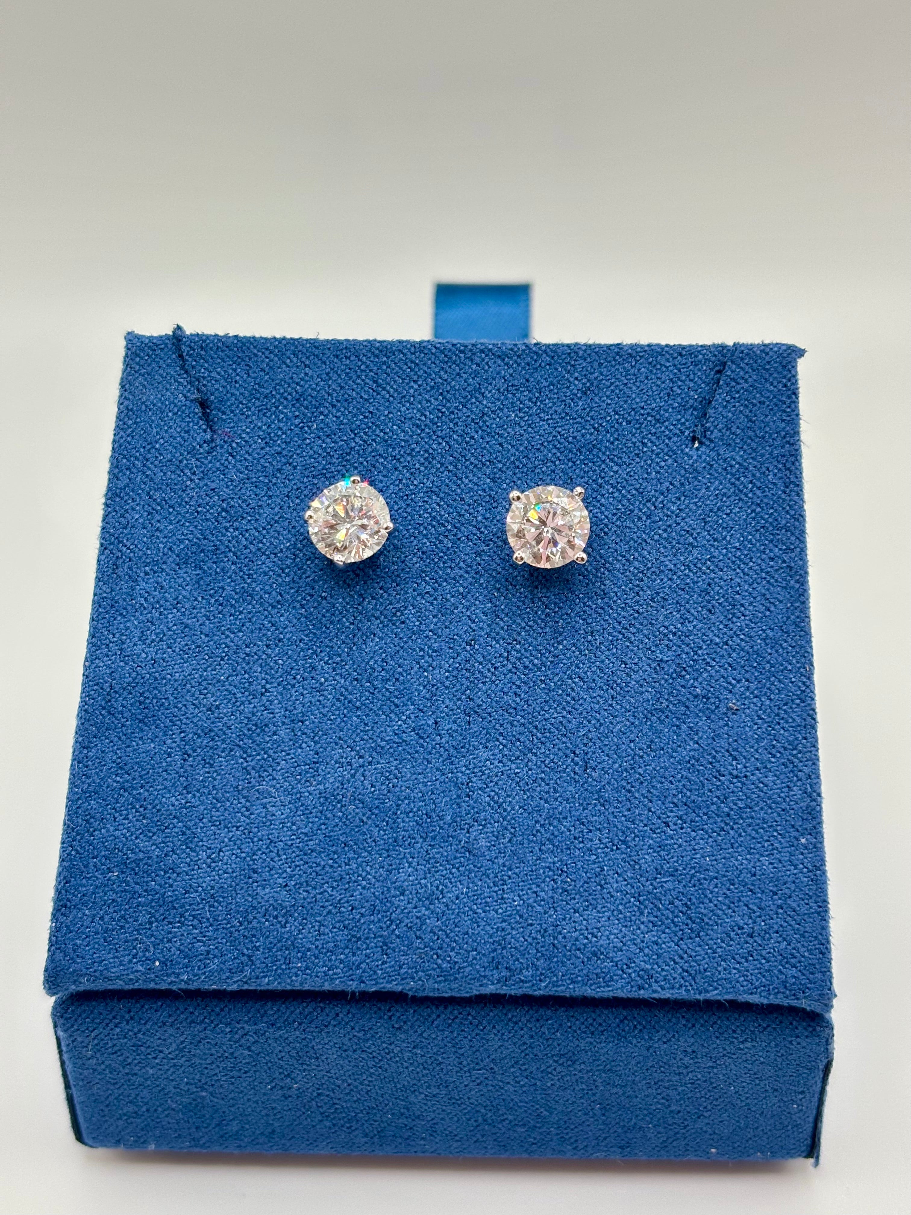 Round brilliant lab diamond studs in 14K white gold four-prong setting on blue box
