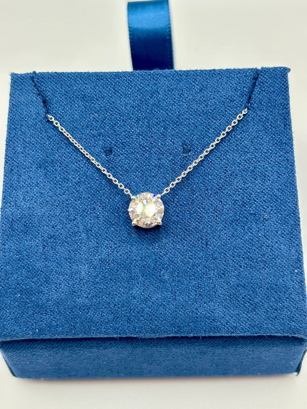 1.5 carat lab diamond solitaire station necklace in 14K white gold on blue velvet box, top view