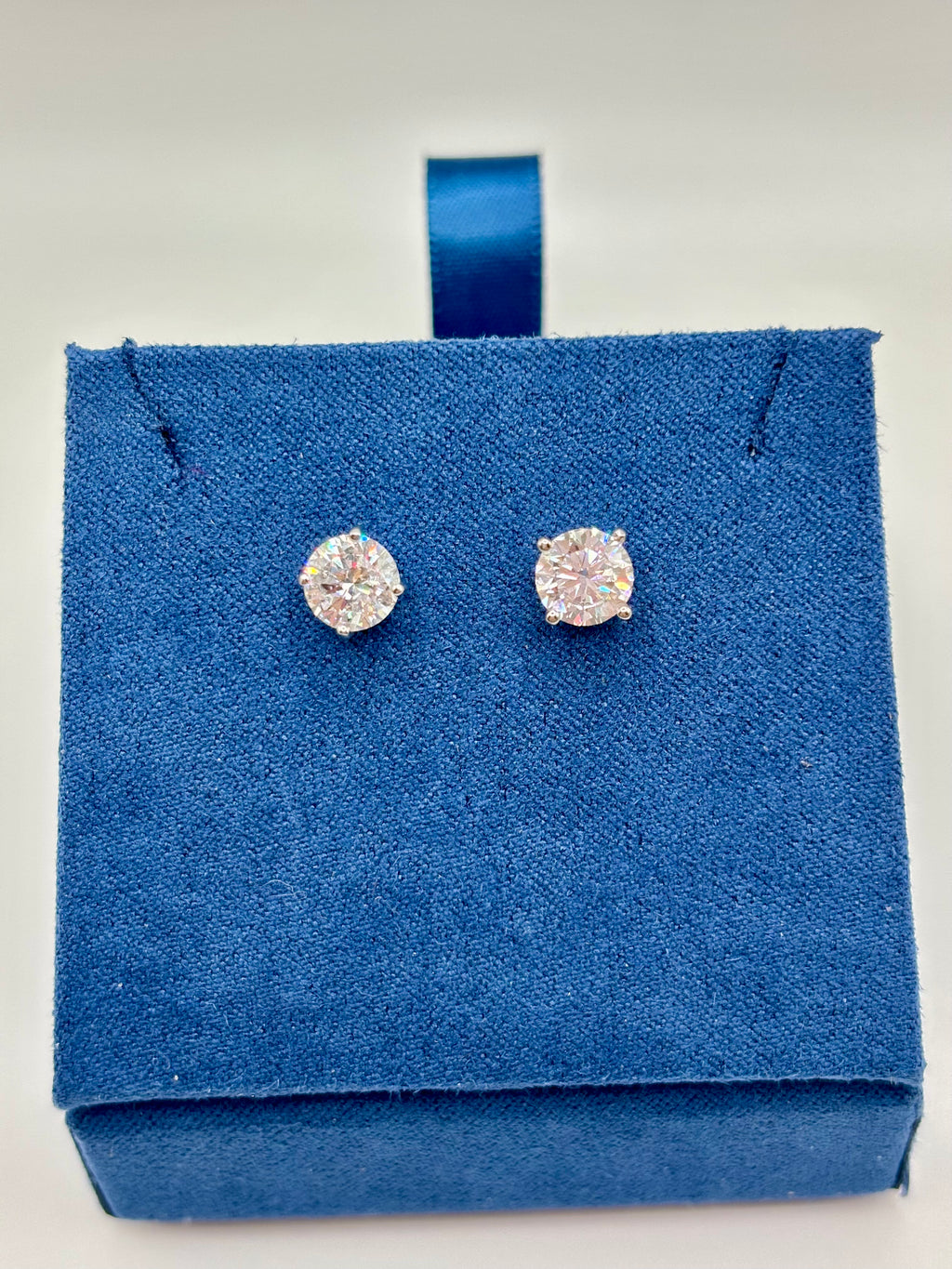 2 CTW lab grown diamond studs in 14K white gold on blue velvet box, close-up