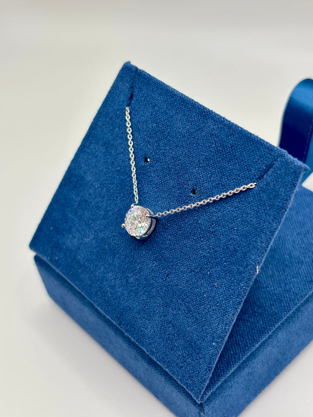1.5ct lab diamond station necklace in white gold, angled view on blue jewelry box