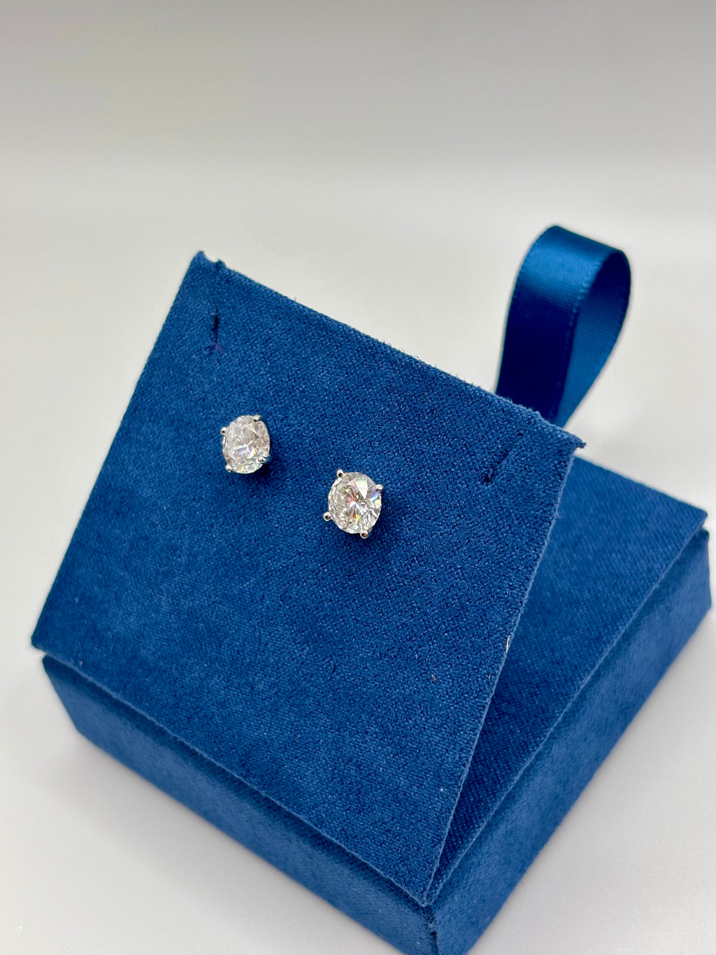 2 carat total weight lab diamond stud earrings in white gold, angled view on blue box