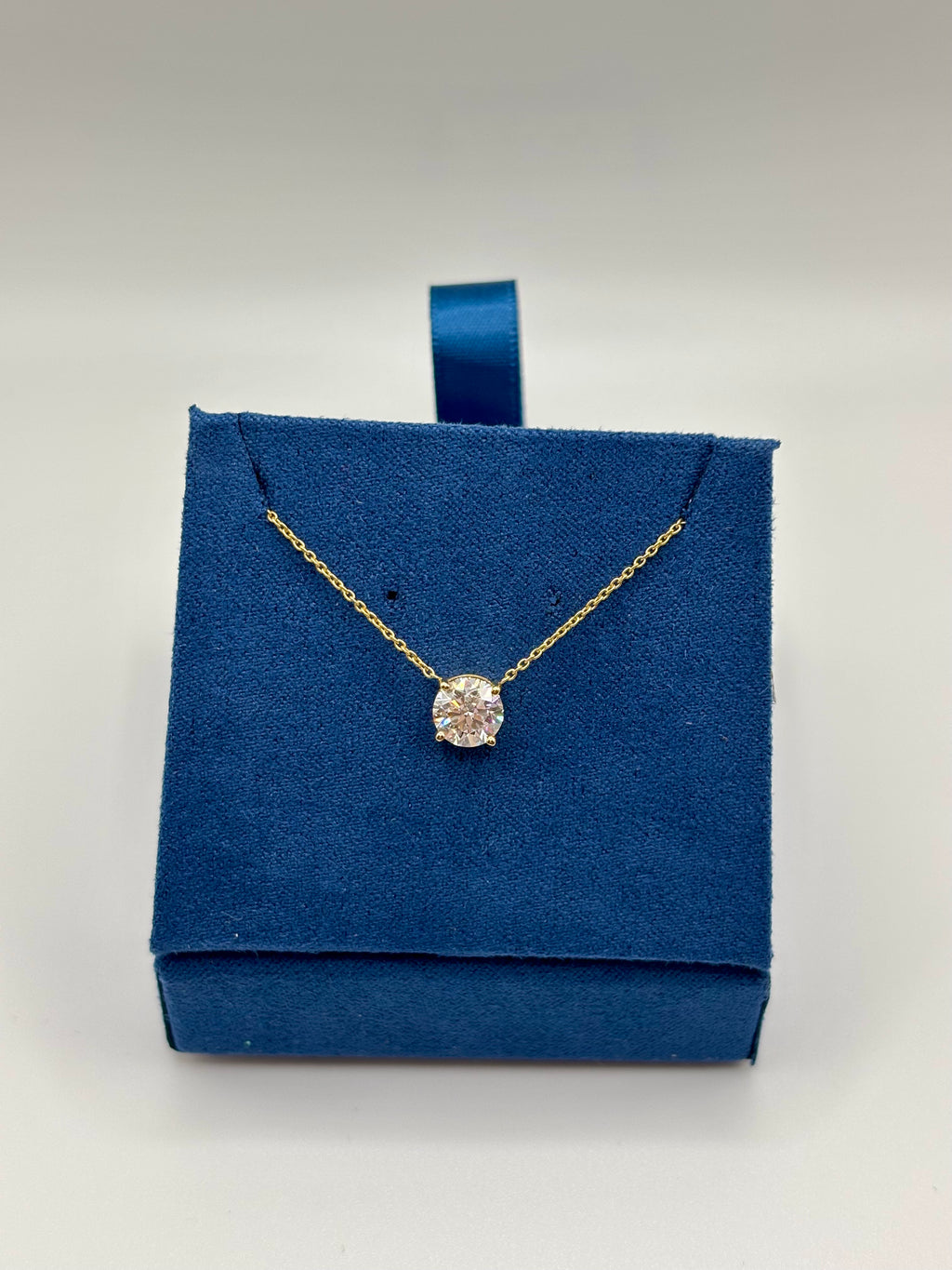 Lab diamond station necklace in 14K yellow gold on velvet box, angled view