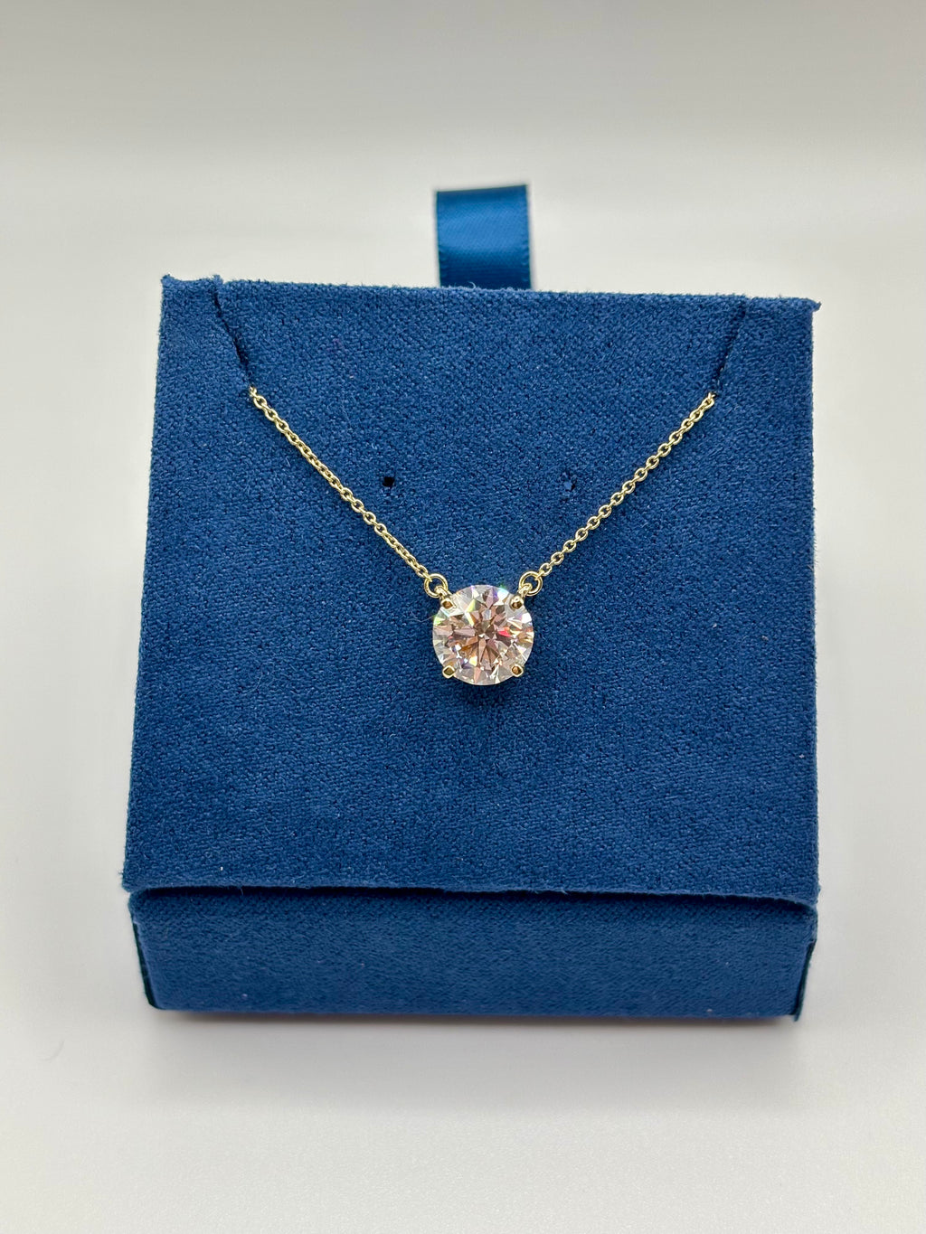 2 carat lab diamond station necklace displayed on blue velvet box, front view